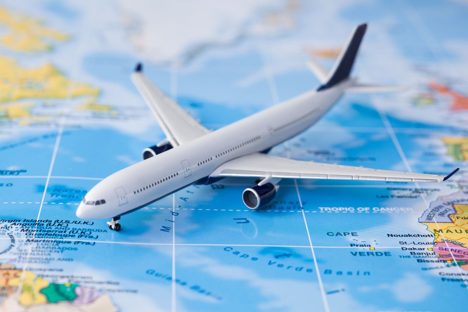 A model airplane rests on a world map, positioned near Africa and the Middle East, with its nose pointing towards the Indian Ocean—an inspiring reminder of staying healthy while traveling through diverse landscapes.