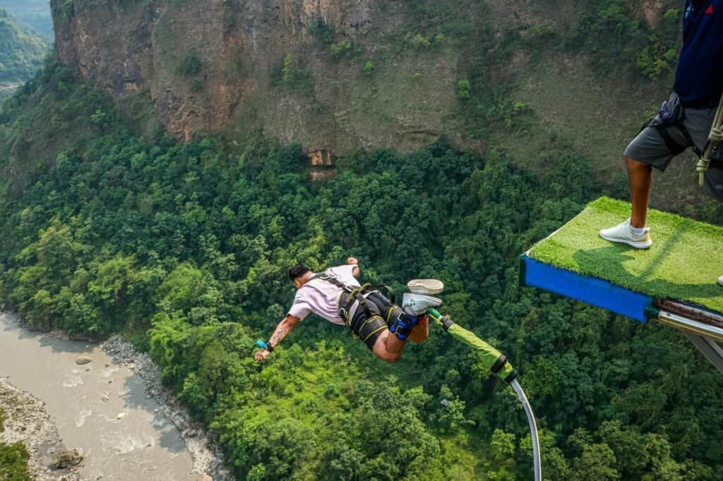 Experience the thrill of bungee jumping off a platform with a river and lush greenery below—one of the ultimate summer adventure ideas.