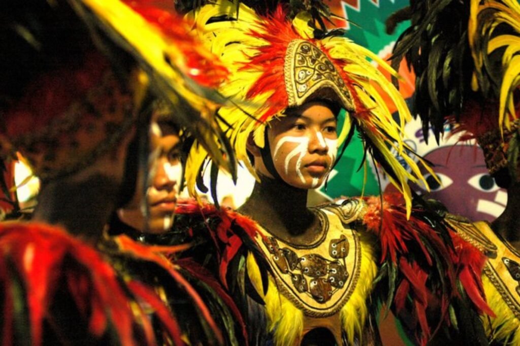 Performers in colorful feathered costumes and face paint bring to life a vibrant cultural festival, offering an unforgettable experience in one of the world's most cheap places to travel.