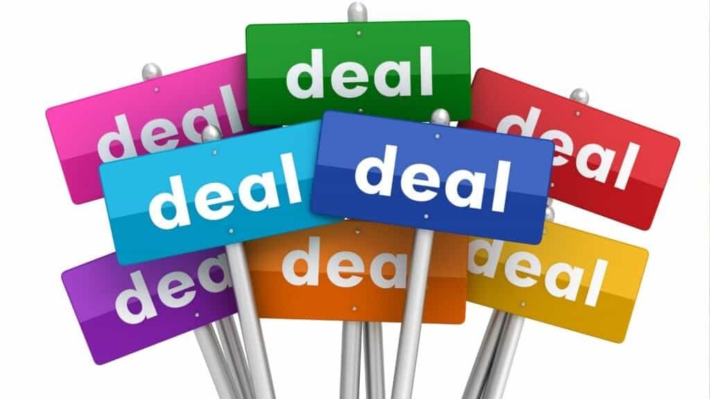 Several colorful signs, each displaying the word "deal" in white lowercase letters, are clustered together against a plain background—perfect inspiration for tips on how to visit Disneyland on a budget.